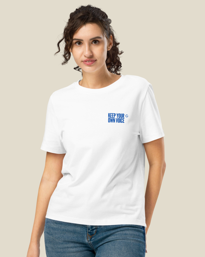 Close view of the KEEP YOUR OWN VOICE statement printed on the left chest of the Women's fit shirt, in White.